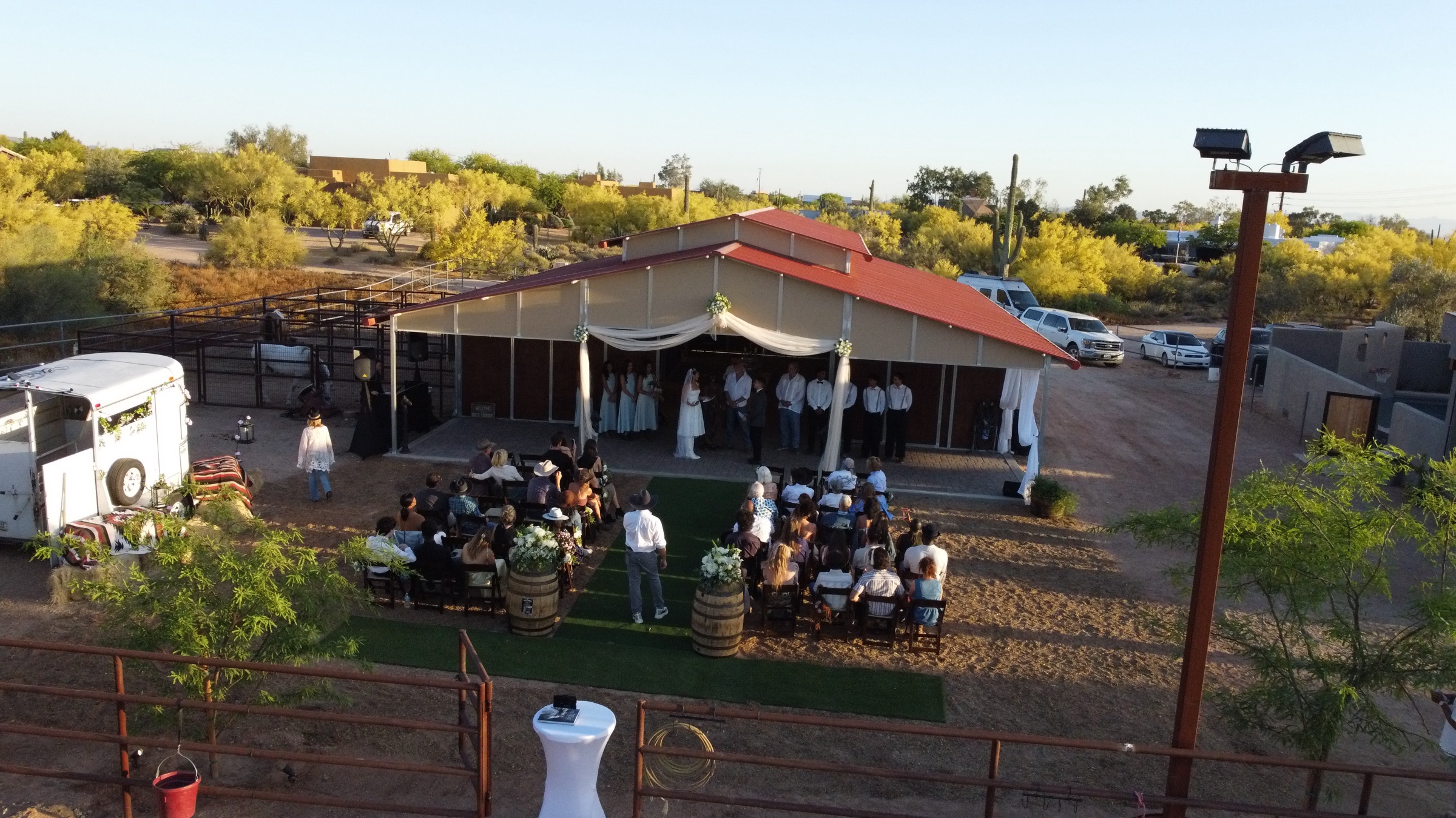 Aerial view of a wedding ceremony arranged in front of the ranch barn
